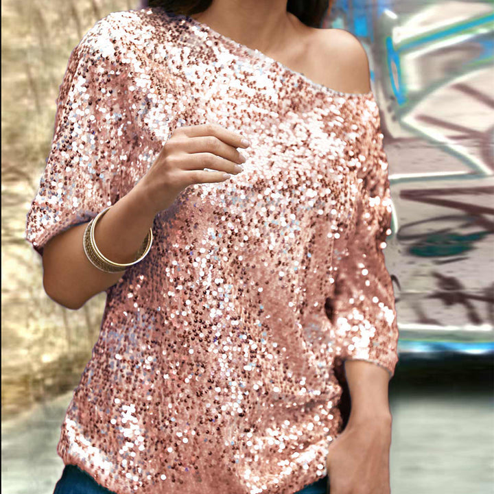 Kvinders glitrende top med off-shoulder design og paliettrim.