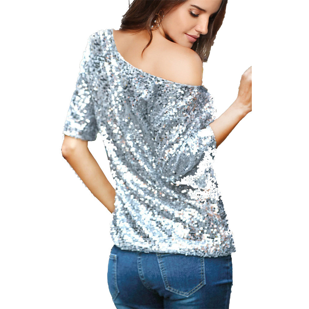 Kvinders glitrende top med off-shoulder design og paliettrim.