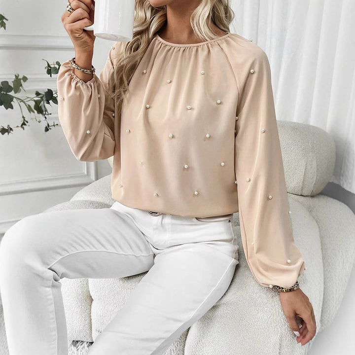 Damernes elegante bluse med perleprydede detaljer og brede ærmer Stilla