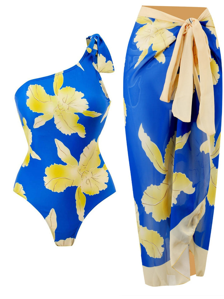 Dame ensartet badedragt med asymmetrisk design og blomsterwrapnederdel Stilla