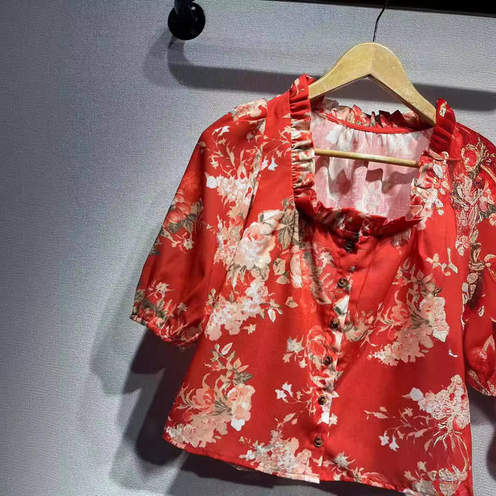 Damebluse i romantisk vintage-stil med blomstermønster og voluminøse pufærmer Stilla
