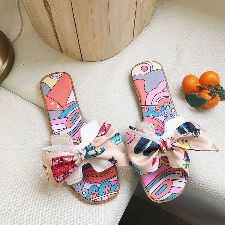 Dame slide-sandaler med farverige trykmotiver og elegant sløjfeapplikation Stilla