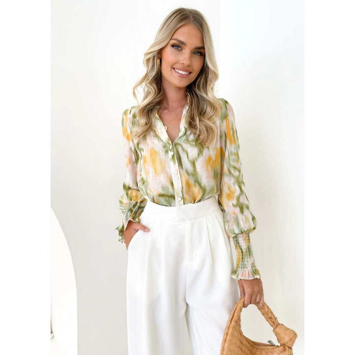 Damebluse med blomsterprint og knaplukning Stilla
