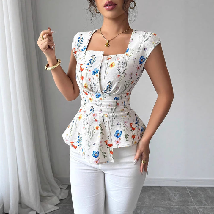 Damebluse med tætsiddende peplum-silhuet og blomsterdesign Stilla