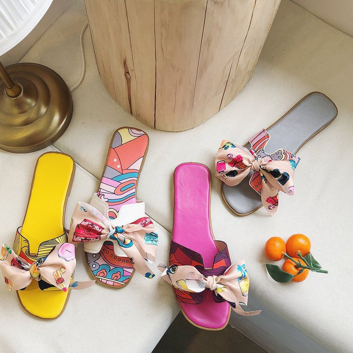 Dame slide-sandaler med farverige trykmotiver og elegant sløjfeapplikation Stilla