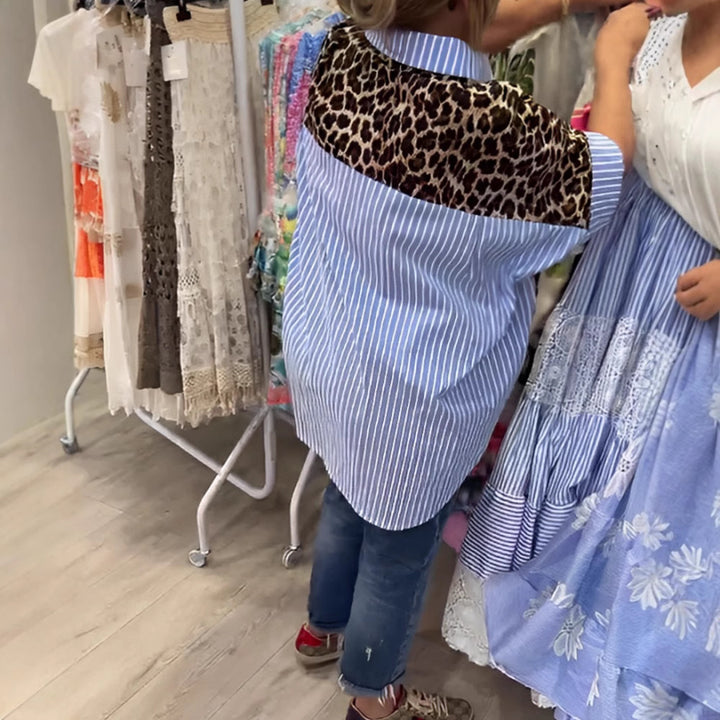 Dame med vidt skårne poncho-tunika med leopardprint og dekorative flamingo-applikationer Skovae。