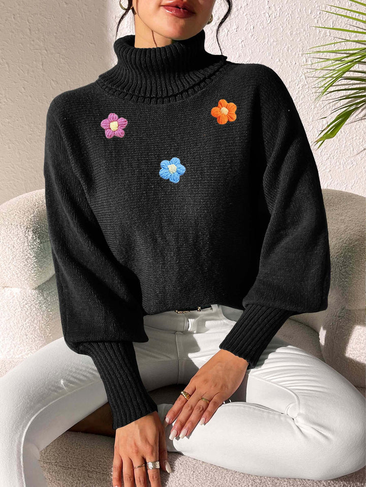 Dame moderigtigt strikpullover med høj krave og farverige blomsterapplikationer Stilla