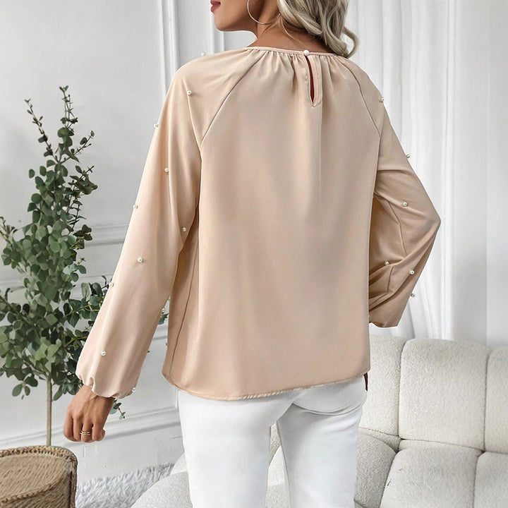Damernes elegante bluse med perleprydede detaljer og brede ærmer Stilla