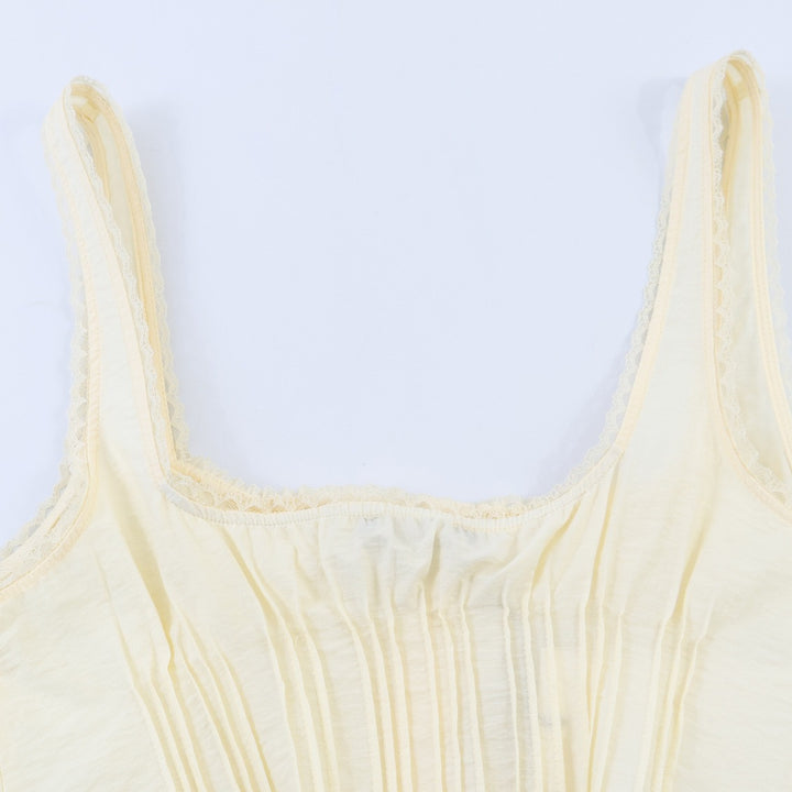 Dame-crop-top med fine folder og dekorknapper Skovae