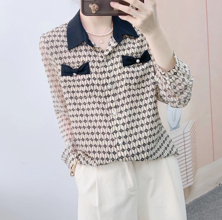 Damebluse med modeprint og elegante sløjfeapplikationer Stilla