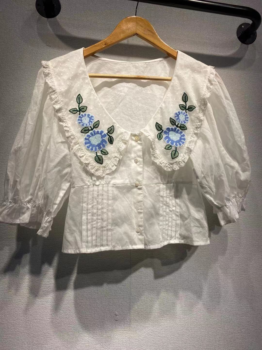 Damebluse med detaljeret blomsterkravebehandling og slidsede ærmer Stilla