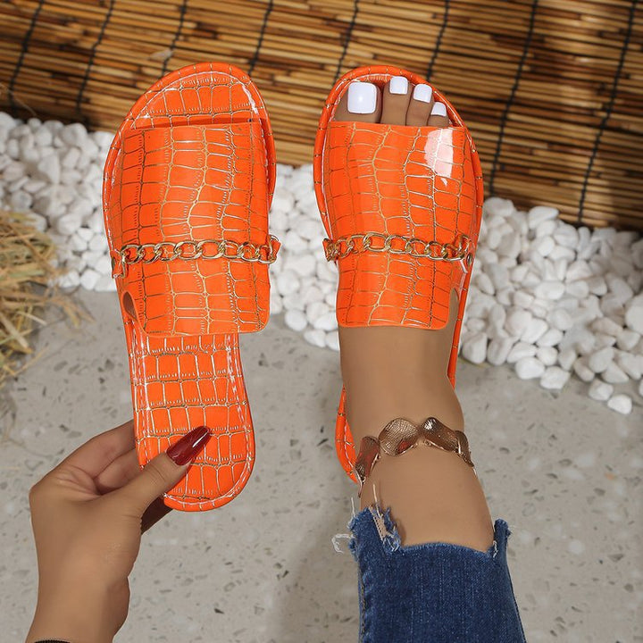 Dame stilige slippers med glitrende krokodillemønster og moderigtigt kædedetail Stilla