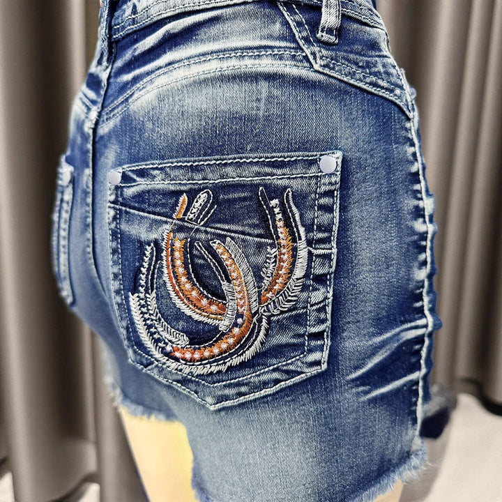 Dame denim-shorts i moderne distressed stil med frynsede kanter Stilla