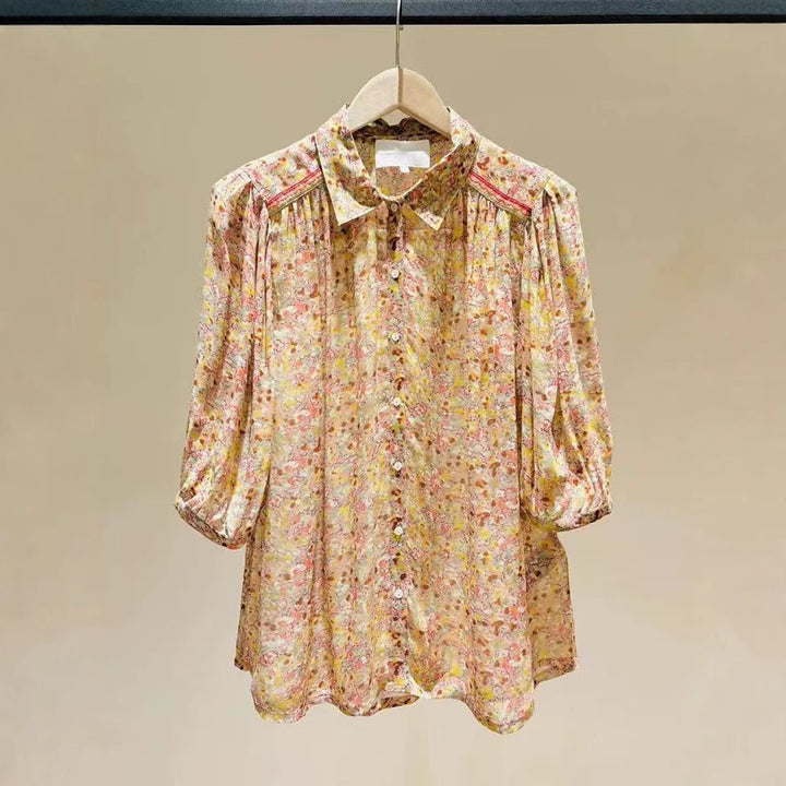 Damebluse med blomsterprint i heltryk og fashionable puffærmer Stilla