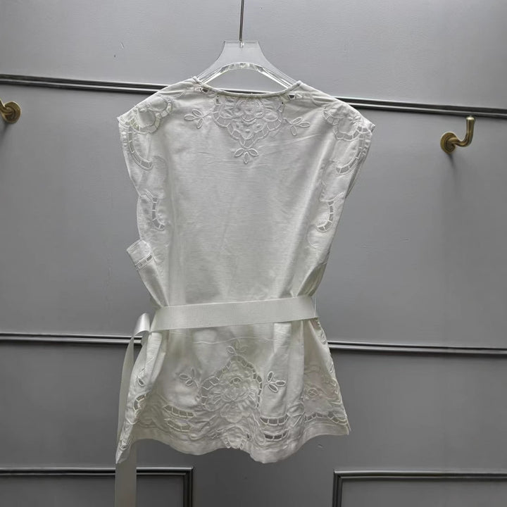 Damebluse med elegant hulmønster og floralt applikationsdesign Stilla