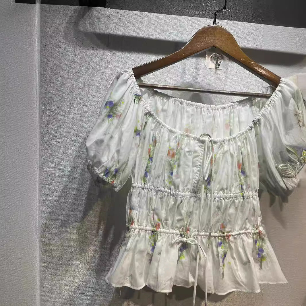 Damebluse med innovativt flæsedesign og blomstret tryk Stilla