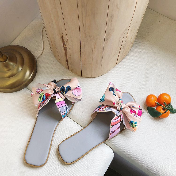 Dame slide-sandaler med farverige trykmotiver og elegant sløjfeapplikation Stilla