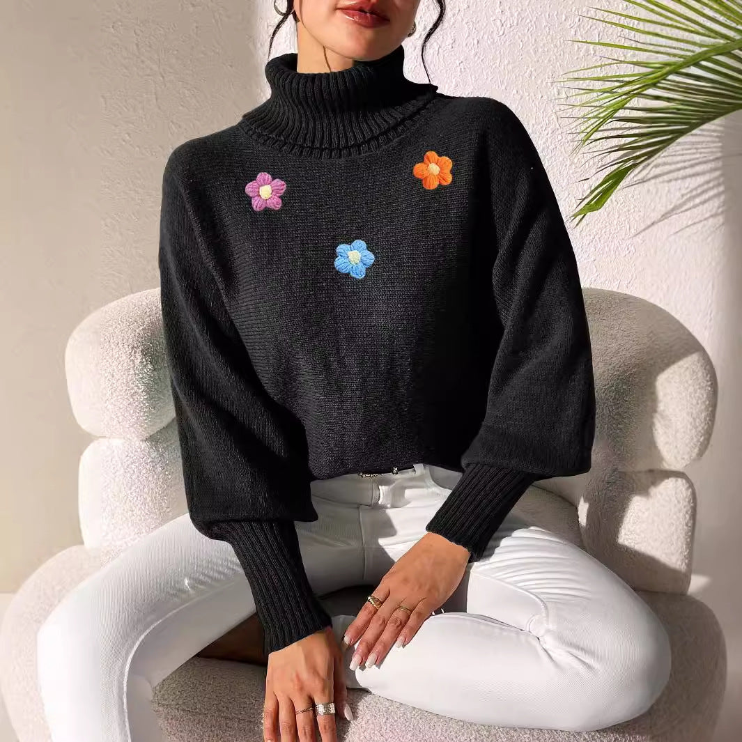 Dame moderigtigt strikpullover med høj krave og farverige blomsterapplikationer Stilla