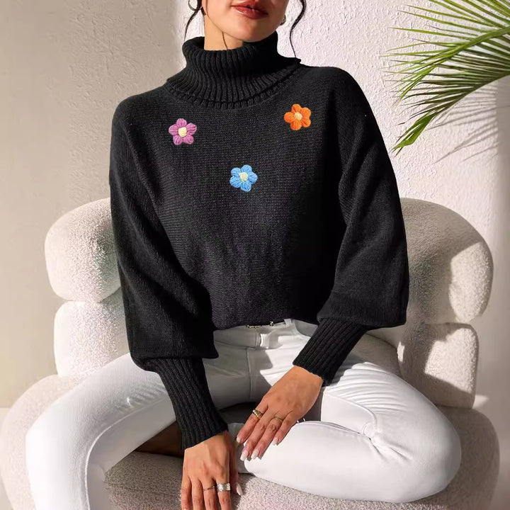 Dame moderigtigt strikpullover med høj krave og farverige blomsterapplikationer Stilla