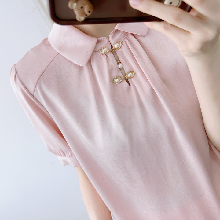Damebluse med modetrends knapdetaljer og elegant højkrave Stilla