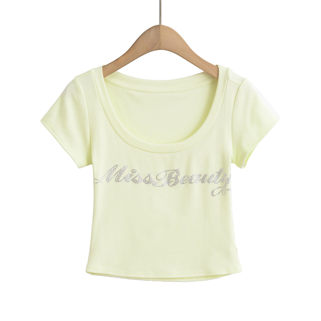 Dame crop-top med elegant rund hals og glitrende skrift Stilla