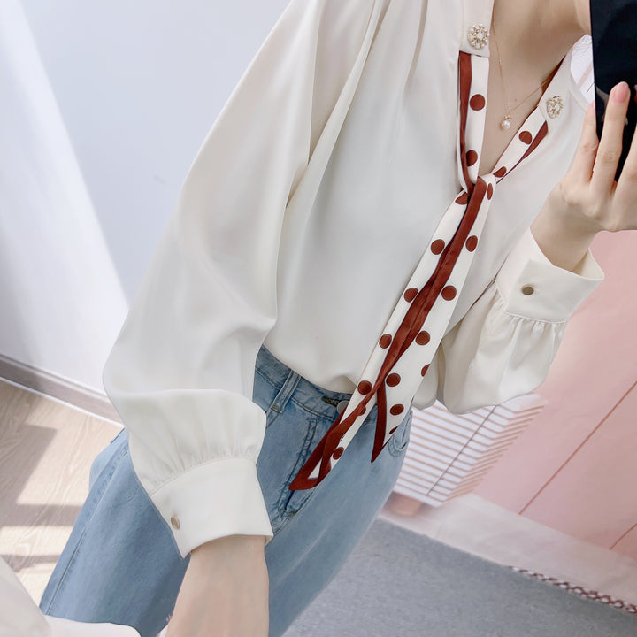 Damebluse med dekorativt bånd og fashionable puffærmer Stilla