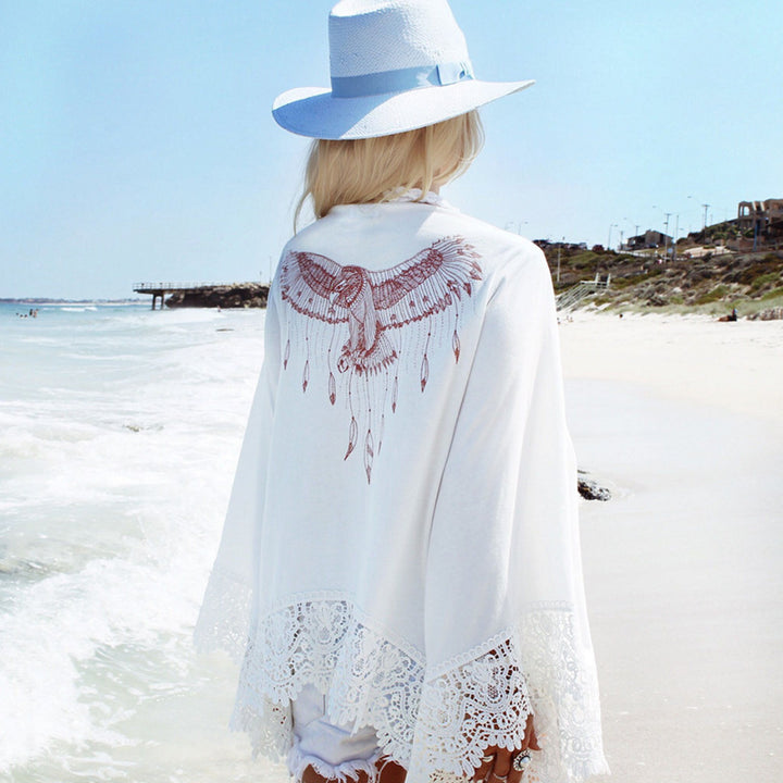 Dame etno-inspireret strandponcho med spidsdetaljer og kunstnerisk fuglemotiv Stilla