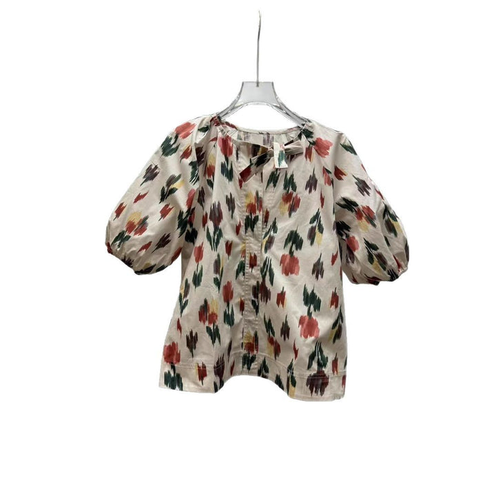 Damebluse med dekorativt sløjfekrave og florale mønstre Stilla