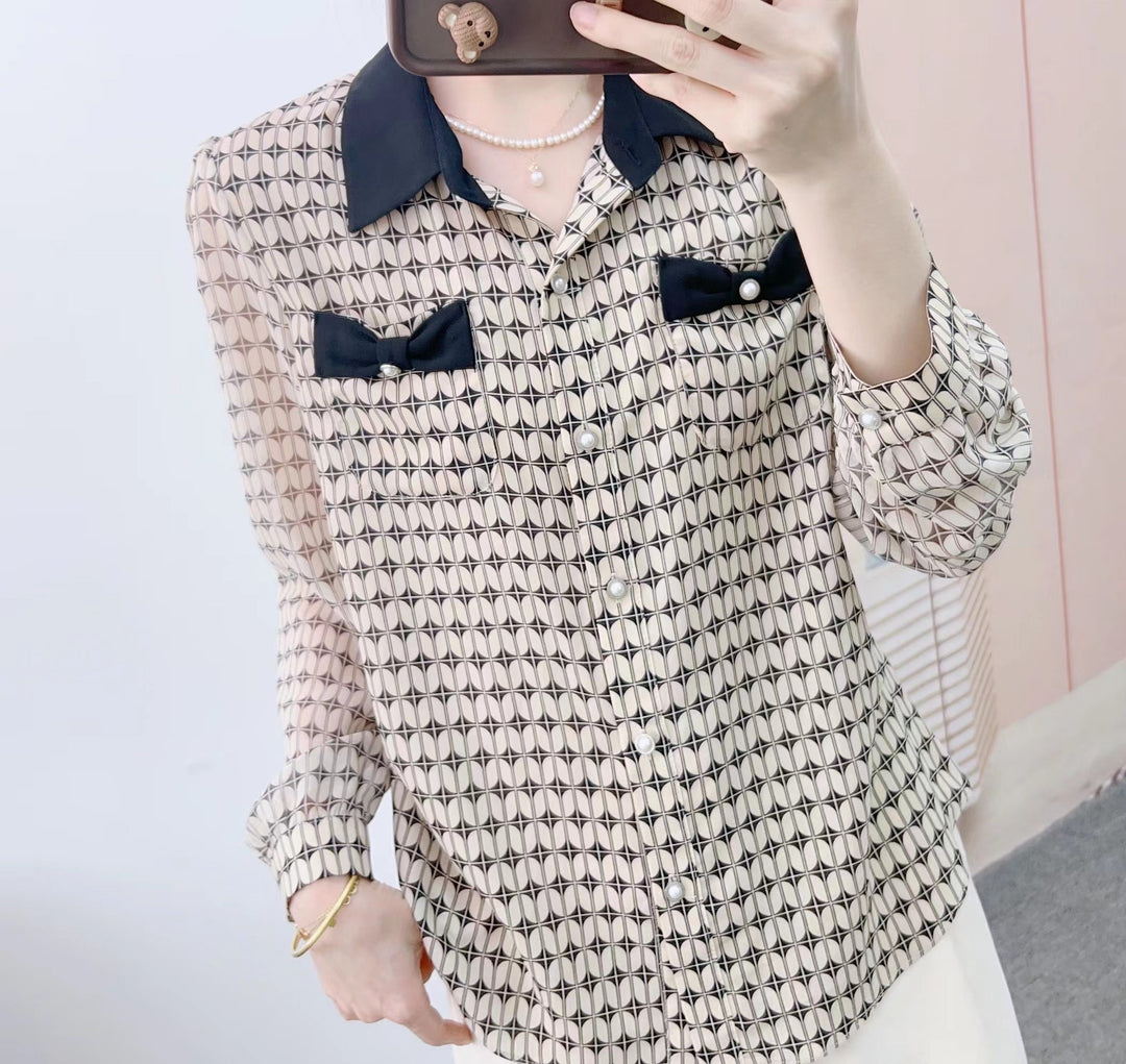 Damebluse med modeprint og elegante sløjfeapplikationer Stilla