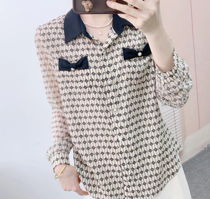 Damebluse med modeprint og elegante sløjfeapplikationer Stilla