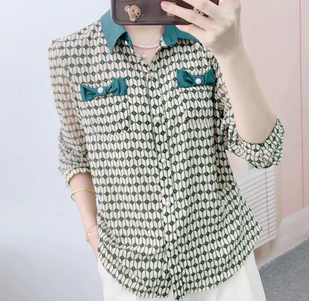 Damebluse med modeprint og elegante sløjfeapplikationer Stilla