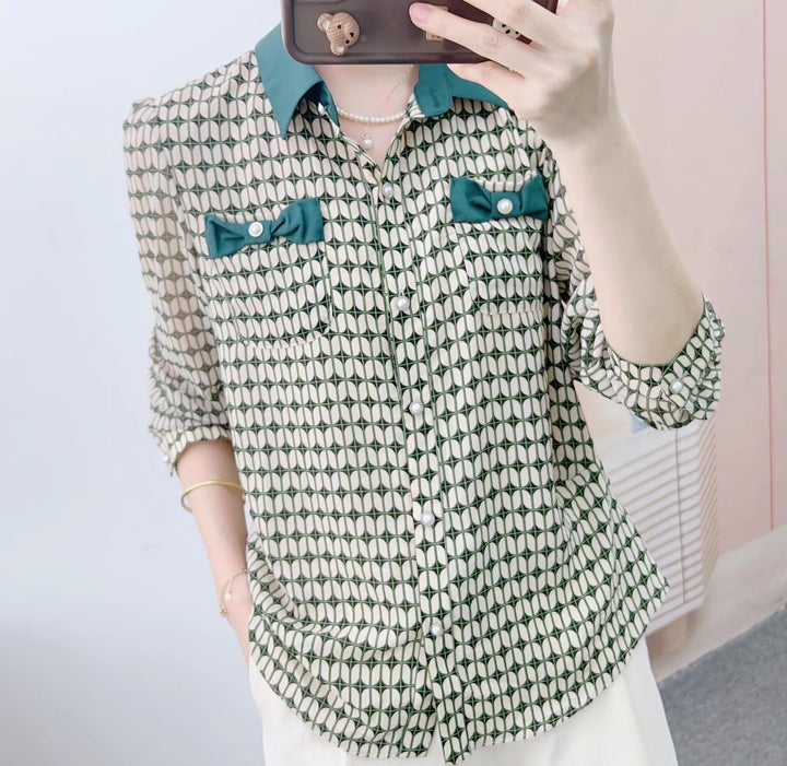 Damebluse med modeprint og elegante sløjfeapplikationer Stilla