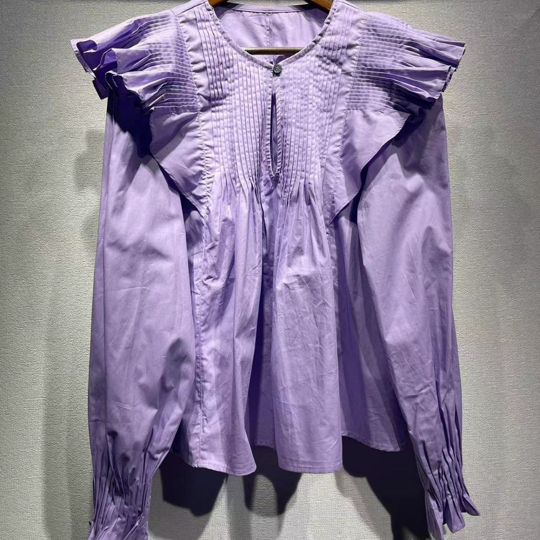Damebluse med voluminøse flæsedetaljer og særpræget plisséfold Stilla