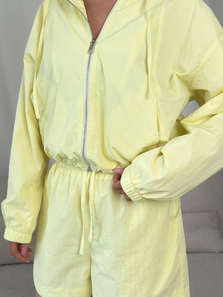 Kvinders sporty sæt med kortærmet bluse og hættejakke samt elastisk talje.