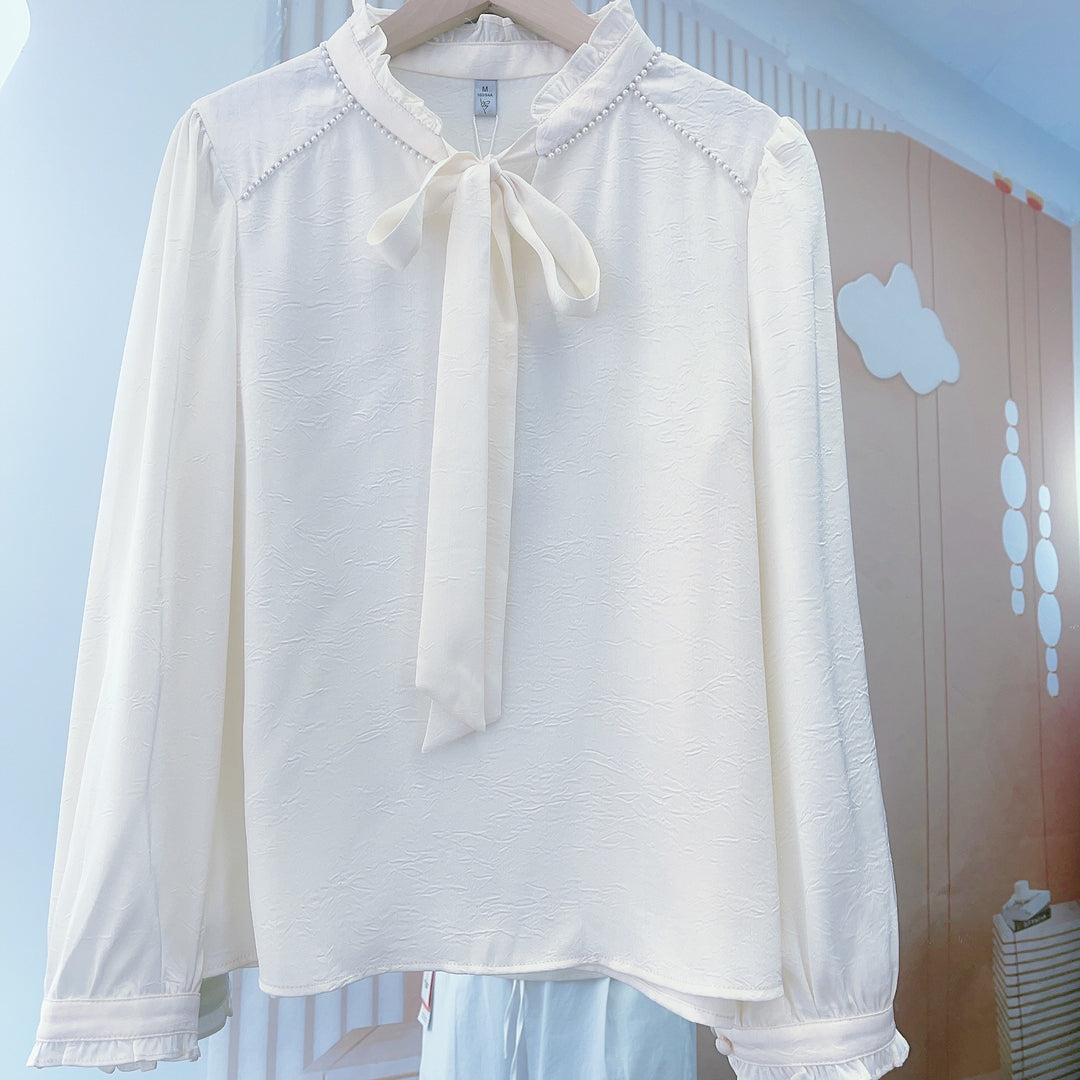 Damebluse med flæsedetaljer og elegant sløjfe Stilla