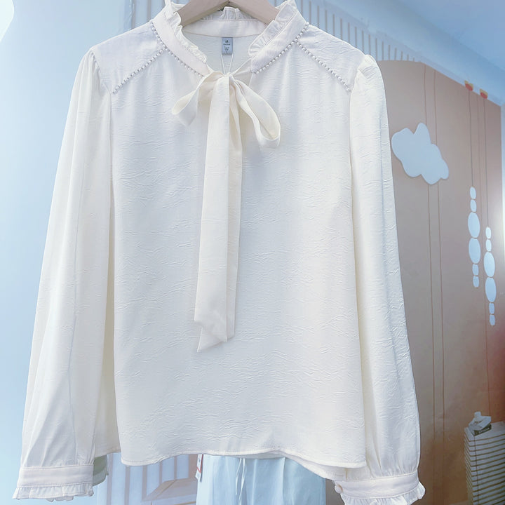 Damebluse med flæsedetaljer og elegant sløjfe Stilla