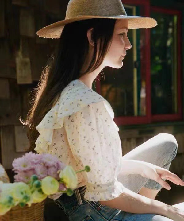 Damebluse med elegante flæsedetaljer og blomstret mønster Stilla