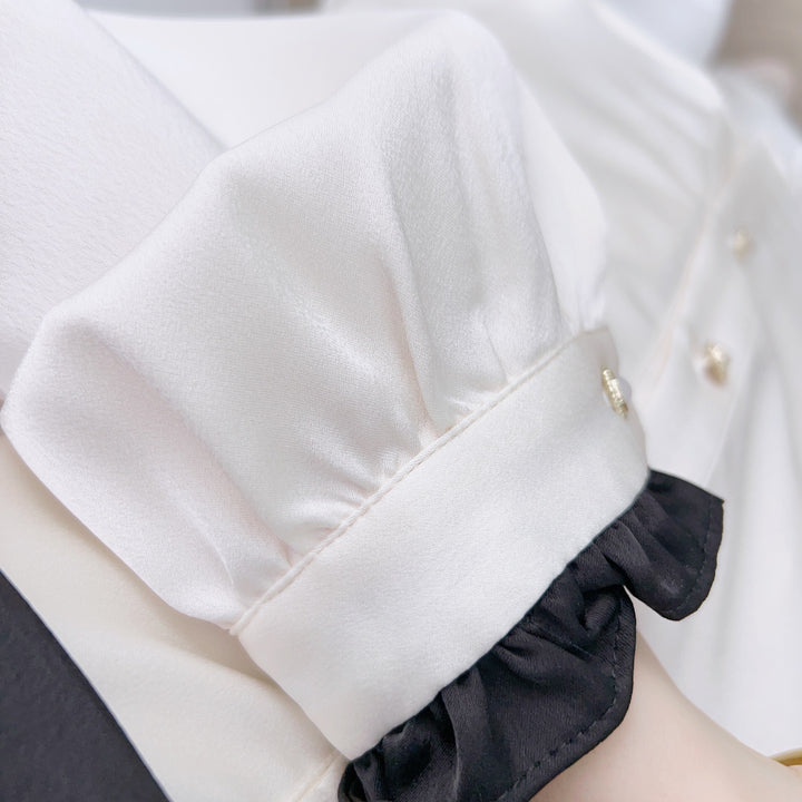 Damebluse med dekorativt bindebånd og elegante pufærmer Stilla