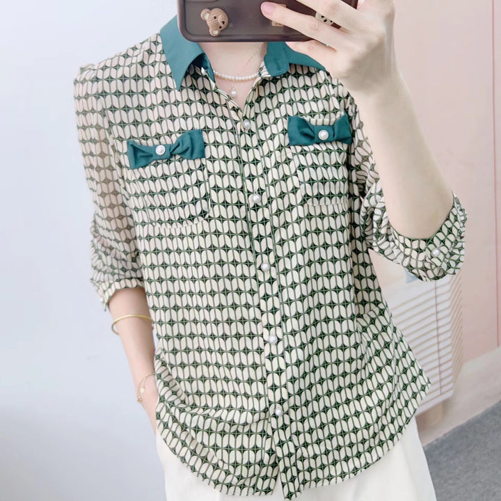 Damebluse med modeprint og elegante sløjfeapplikationer Stilla