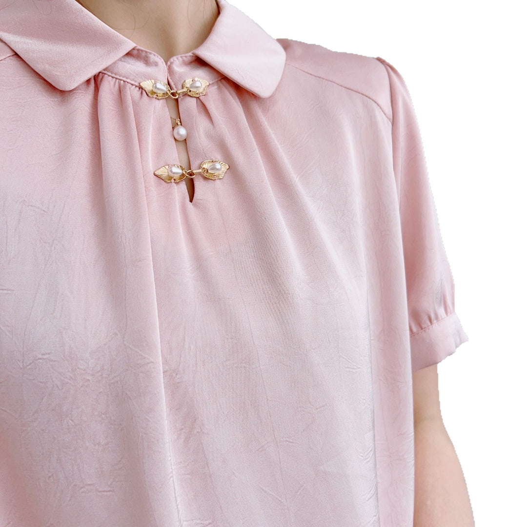 Damebluse med modetrends knapdetaljer og elegant højkrave Stilla