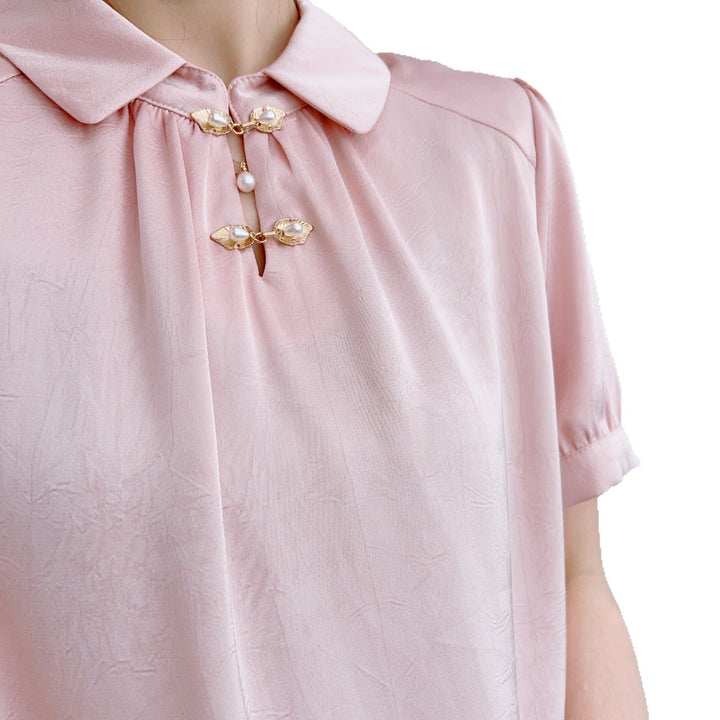 Damebluse med modetrends knapdetaljer og elegant højkrave Stilla