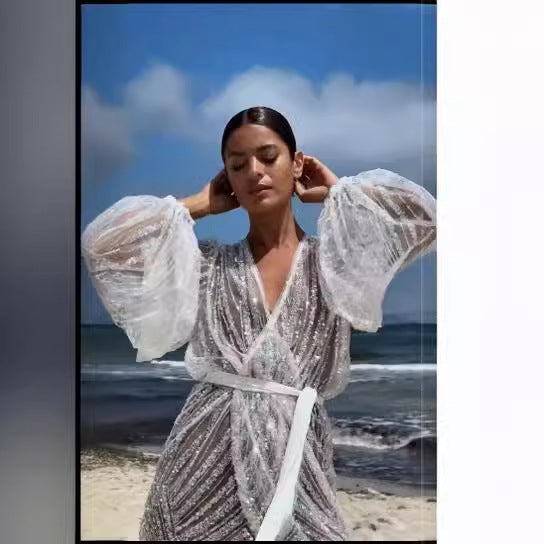 Kvindernes glitrende strandkåbe med elegant bælte og brede flagrende ærmer Skovae