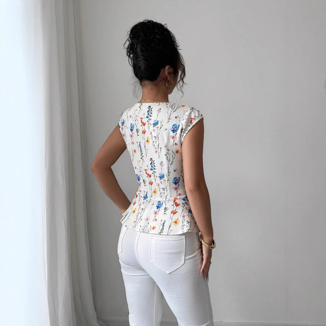 Damebluse med tætsiddende peplum-silhuet og blomsterdesign Stilla