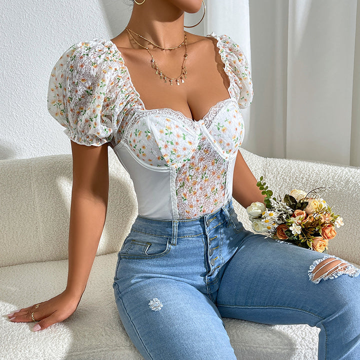 Dame spids-bodysuit med blomsterakcenter og puffærmer Stilla