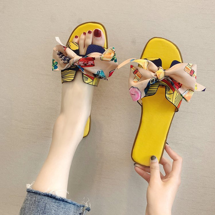 Dame slide-sandaler med farverige trykmotiver og elegant sløjfeapplikation Stilla