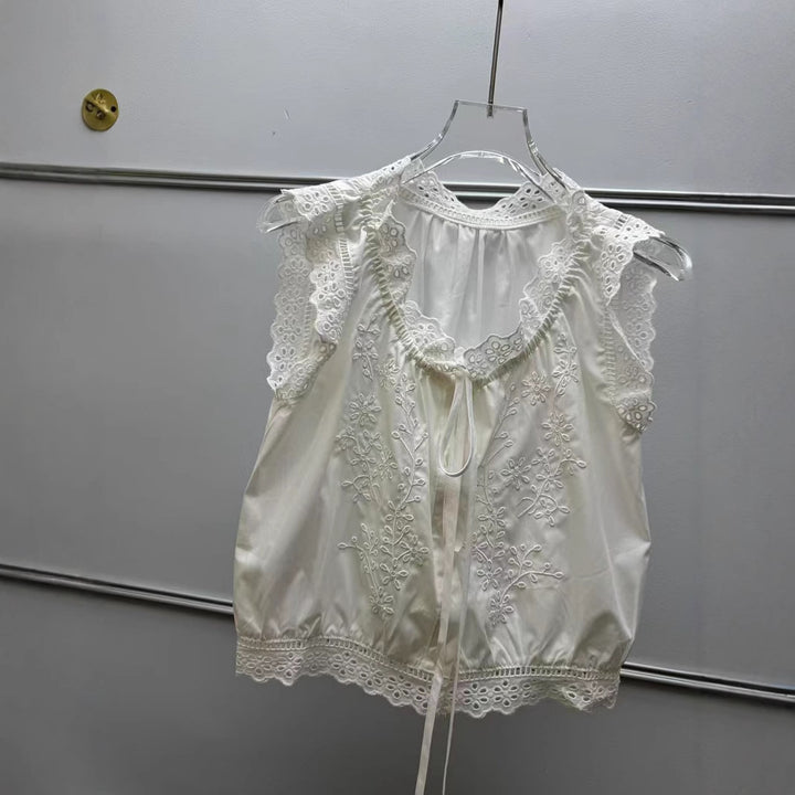 Damebluse med sarte spidsdetaljer og floralt broderidesign Stilla