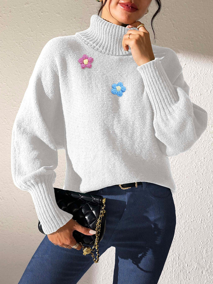 Dame moderigtigt strikpullover med høj krave og farverige blomsterapplikationer Stilla