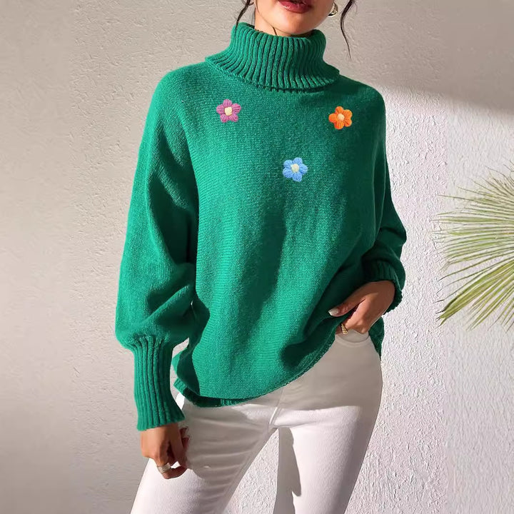 Dame moderigtigt strikpullover med høj krave og farverige blomsterapplikationer Stilla