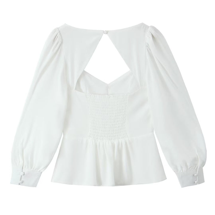 Damebluse med raffinerede puffærmer og elegant rygudskæring Stilla