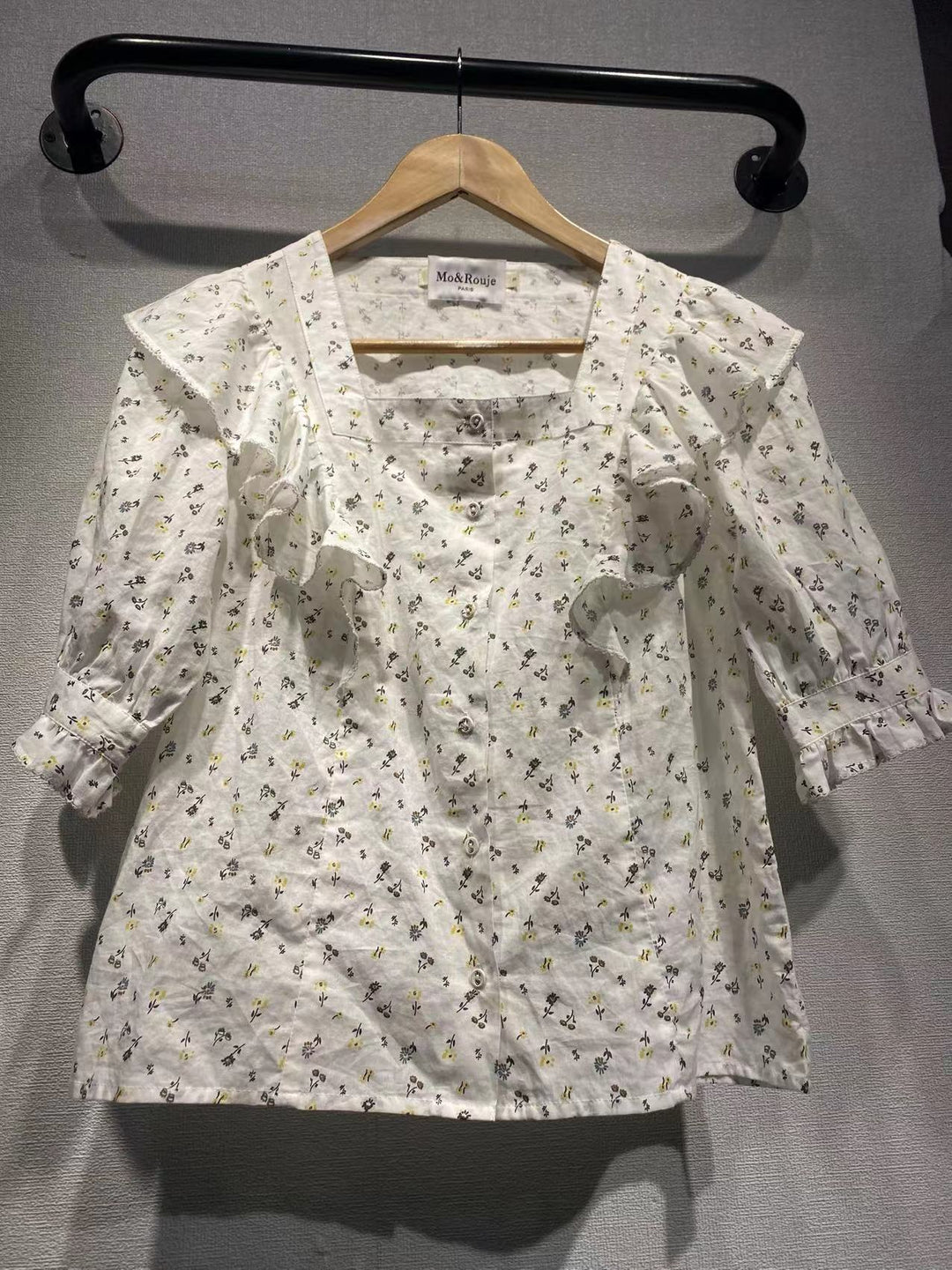 Damebluse med elegante flæsedetaljer og blomstret mønster Stilla
